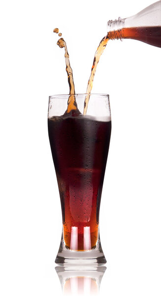 A Bottle of cola soda pouring into a glass over a white background with reflection.