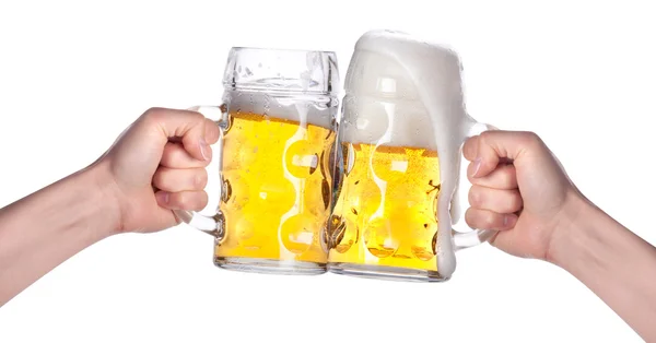 Две руки держат пиво, произнося тост — стоковое фото