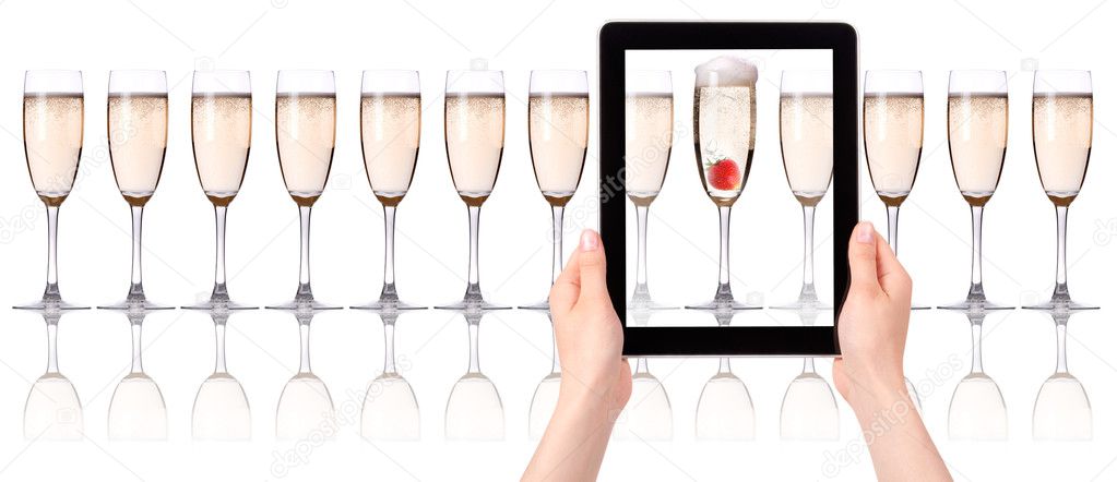 Glass of champagne on tablet computer screen