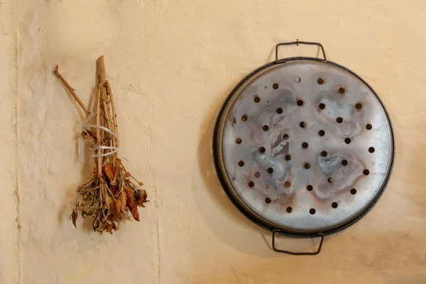 Dryed chilipeppar och pan på en vägg — Stockfoto