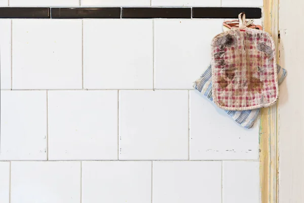 Old Oven Mitts en una pared de cocina sucia —  Fotos de Stock