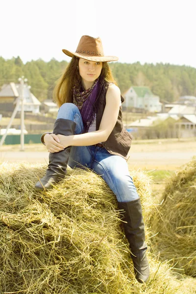 Young girl sitting on the hay — Stock Photo, Image