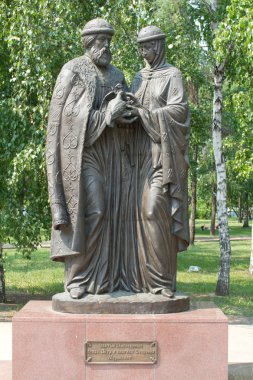 Monument to Peter and Fevronia of Murom in Irkutsk on the background of green leaves clipart