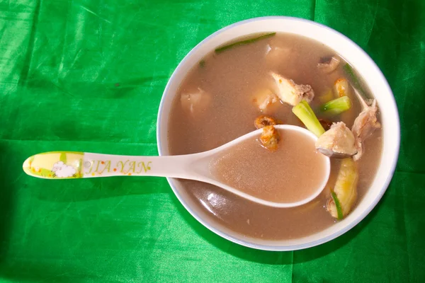 Piatto con una zuppa di pesce laotiano su uno sfondo di stoffa verde — Foto Stock