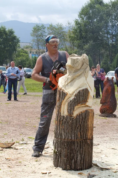 Master carves a bear figurine of a large timber — Stock Photo, Image