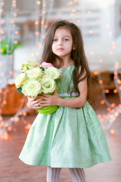 Hübsches kleines Mädchen in schönem grünen Kleid mit Rosen — Stockfoto