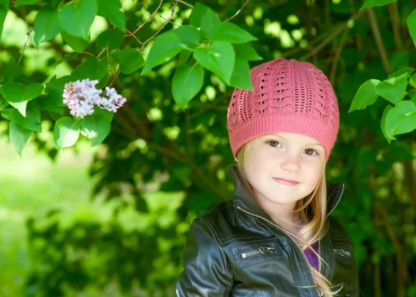 Adorable little girl in pink hat smiling in a park close-up — Stock Photo, Image