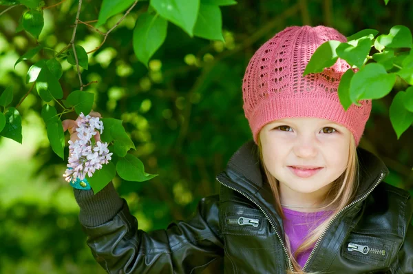 Adorable little girl in pink hat smiling in a park close-up — Stock Photo, Image