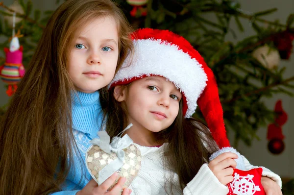 Two adorable girls in front of christmas tree — Stock Photo, Image