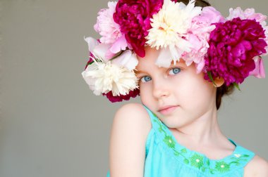 Adorable little girl with wreath from flowers clipart