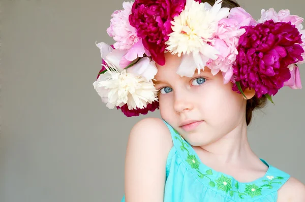 Aranyos kislány és virágok koszorút — Stock Fotó
