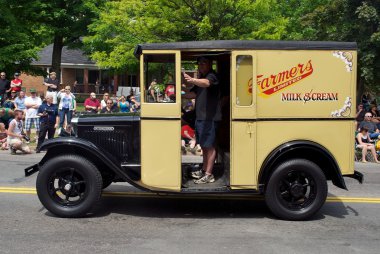 Antique milk truck in parade clipart