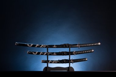 Katana, wakizashi and tanto on blue background. Copy space. clipart