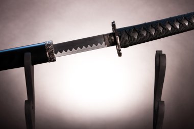 Katana on stand with partially drawn blade, clipart