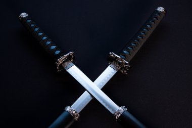 Crossed blades, katana and wakizashi on black background. clipart