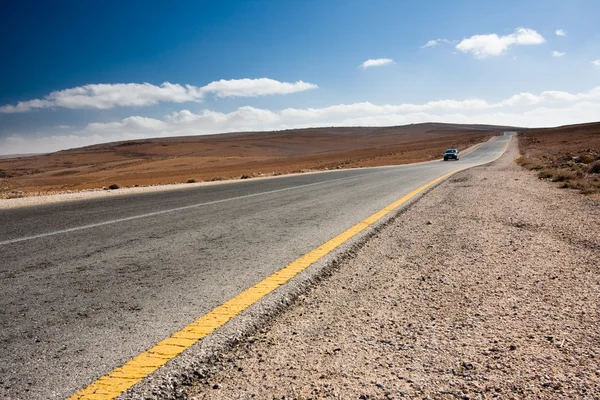 Desert road with blue car — Stock Photo, Image
