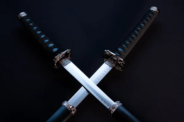 Crossed blades, katana and wakizashi on black background. — Stock Photo, Image