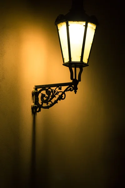 Tmavý náladový obrázek ze staré lampy na zeď — Stock fotografie