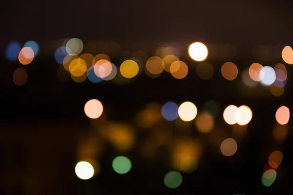 Θολή η νύχτα φωτεινά φώτα της πόλης σε απόσταση — Φωτογραφία Αρχείου