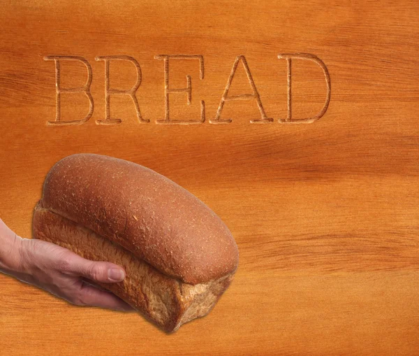 Bochenek chleba, ręka odbędzie się. — Zdjęcie stockowe