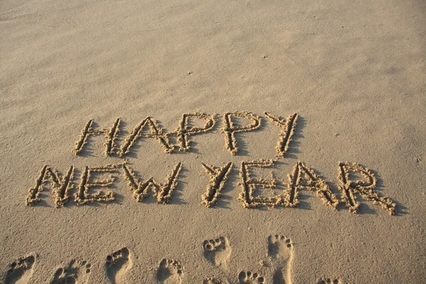 Ευτυχισμένο το νέο έτος γραμμένο στην άμμο. — Φωτογραφία Αρχείου