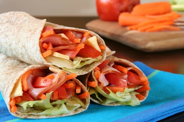 Zdravý oběd, šunka, sýr a zelenina zabalené v celozrnné tortilly. — Stock fotografie