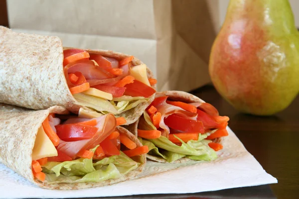 Healthy lunch, ham, cheese and vegetables wrapped in a whole wheat tortilla. — Stock Photo, Image