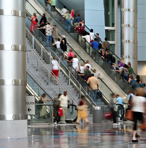 Blurred crowd moving up an escalator — Stock Photo, Image