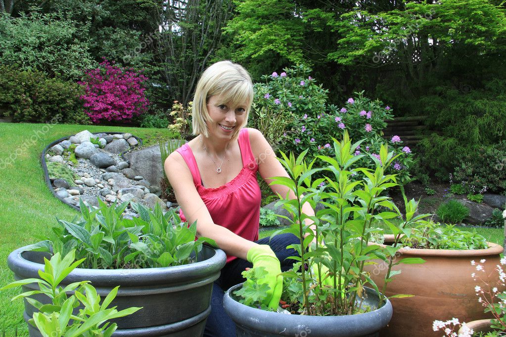 Mujer en el jardín con flores — Foto de stock © Hannamariah #11346995