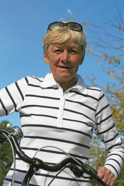 Sixty five year old lady on her bike clipart