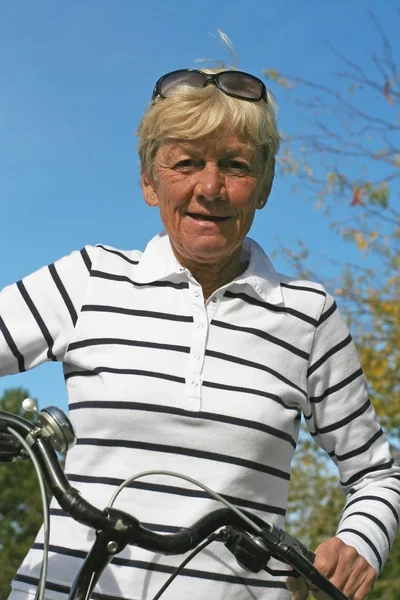 Sesenta y cinco años señora en su bicicleta — Foto de Stock