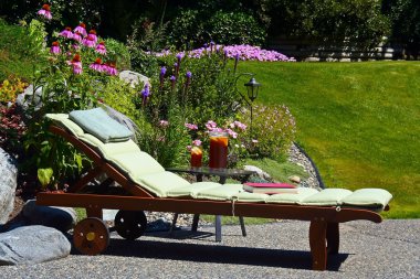 Sun-lounger in a garden clipart