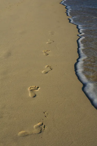 Βήματα στην άμμο κατά μήκος την άκρη του νερού. — Φωτογραφία Αρχείου