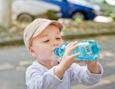 Child drinking from bottle clipart