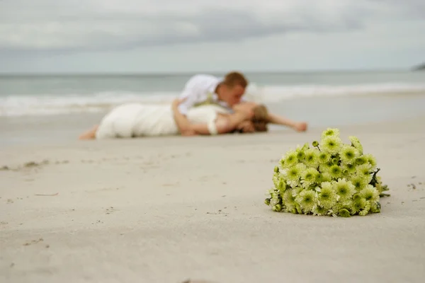 Flores de boda en la playa con novia y novio en el fondo —  Fotos de Stock
