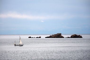 Sailboat and rocks in Croatia clipart