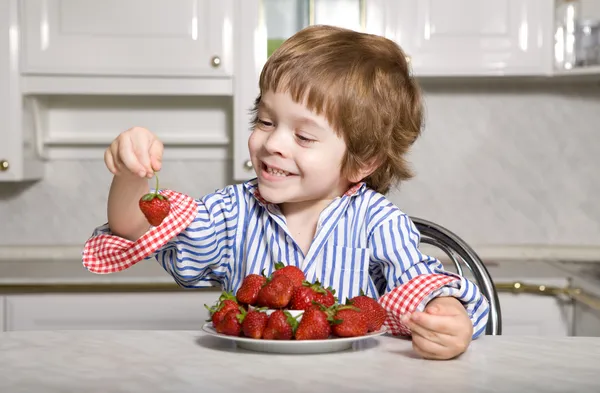 Kleiner Junge mit Erdbeere Stockbild