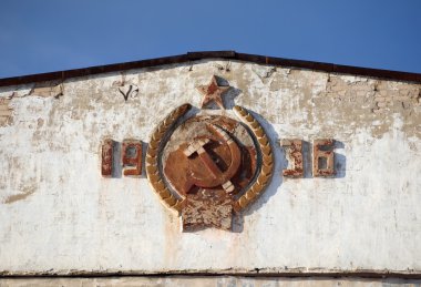 Coat of arms of the USSR on the facade of the old barracks clipart