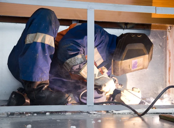 Welder working in cramped conditions — Stock Photo, Image