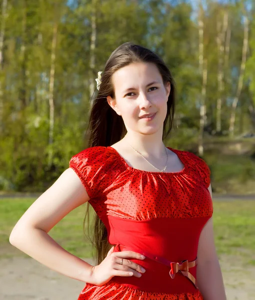 Portret van een mooi meisje in een rode jurk met haar haren — Stockfoto