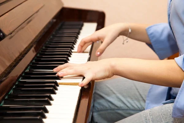 年轻女孩在弹钢琴的手 — 图库照片