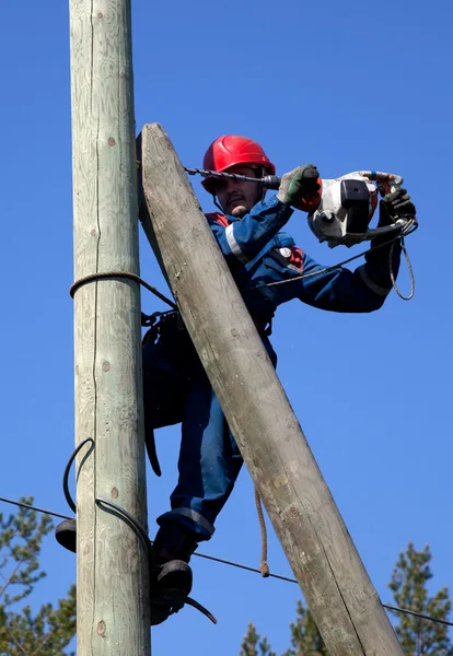 Electrician on a pole makes installation work — Stock Photo, Image
