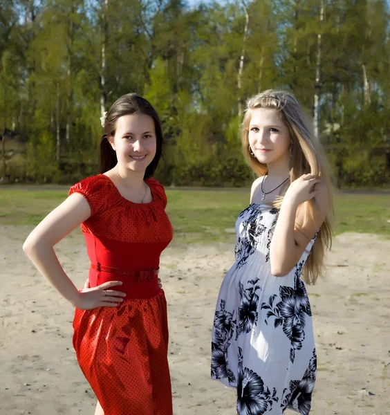 Twee meisjes in jurken wandelen in het park — Stockfoto