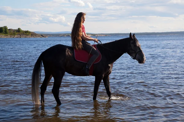 A girl with flowing hair on a horse — Stock Photo, Image