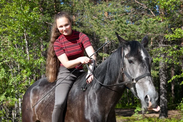 Menina bonita no cavalo preto — Fotografia de Stock