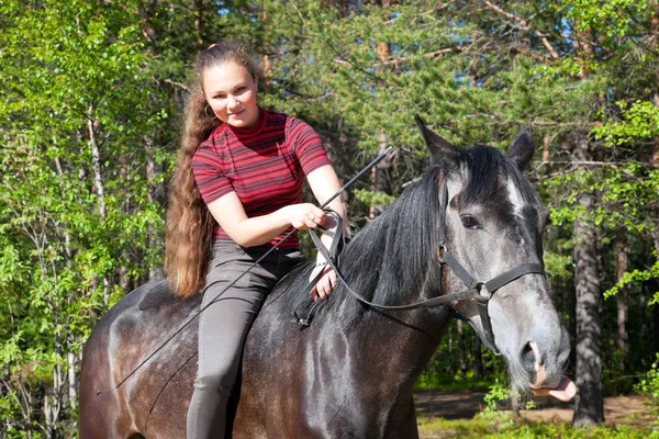 Hermosa chica en caballo negro — Foto de Stock