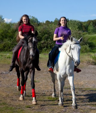 Two girls walking on horseback clipart