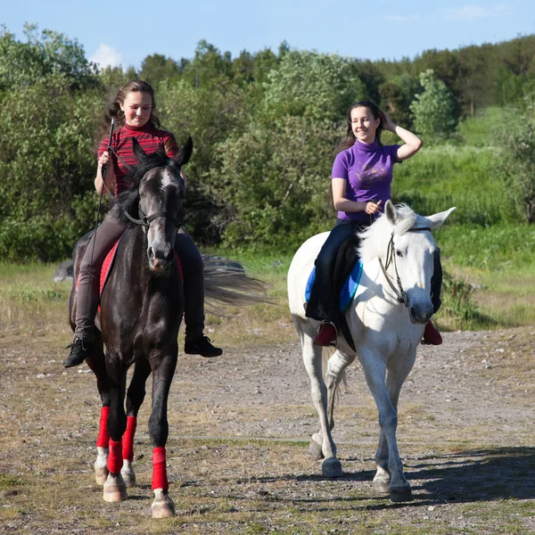 Duas meninas montando cavalos — Fotografia de Stock
