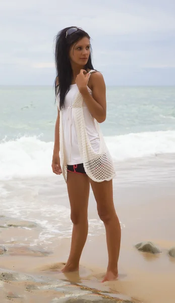 Beyaz giysili bir plajda Slim esmer — Stok fotoğraf
