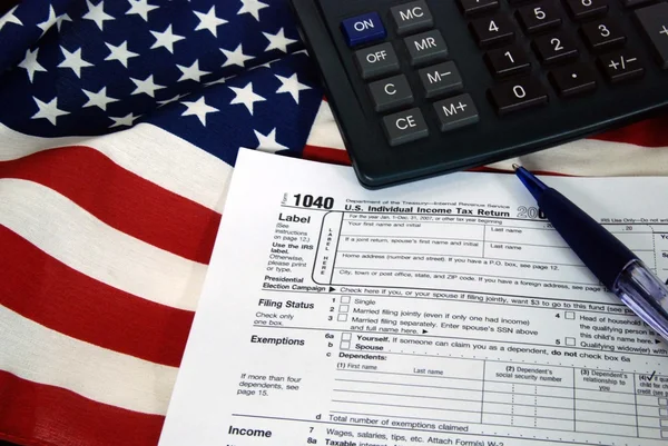 Inkomstenbelasting formulier op vlag — Stockfoto
